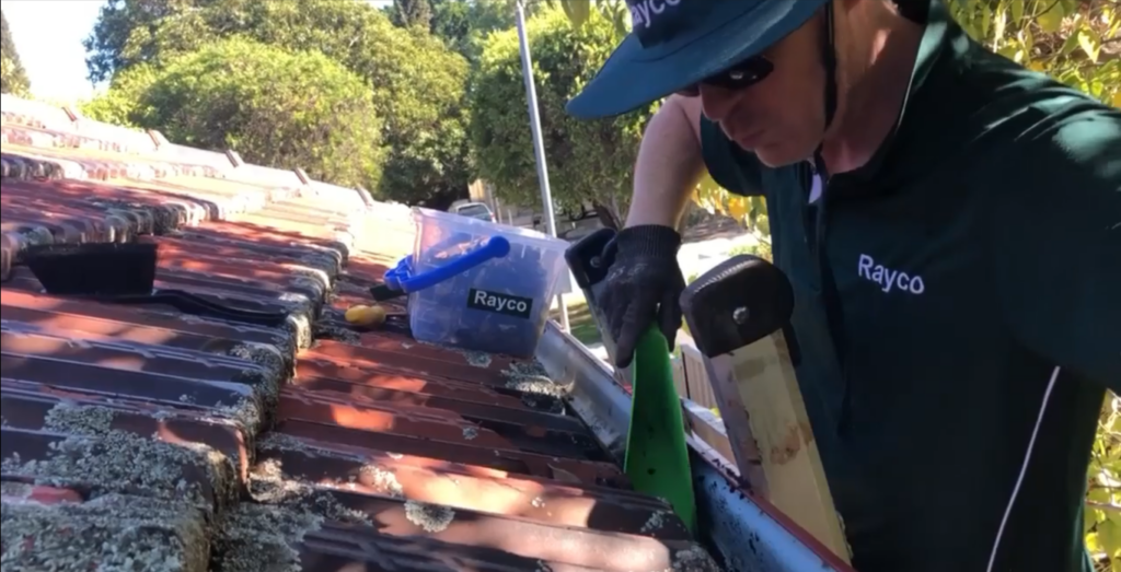 Cleaning gutters and pushing up slipped tiles